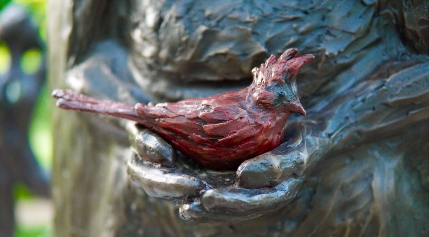 close up of statue holding red cardinal